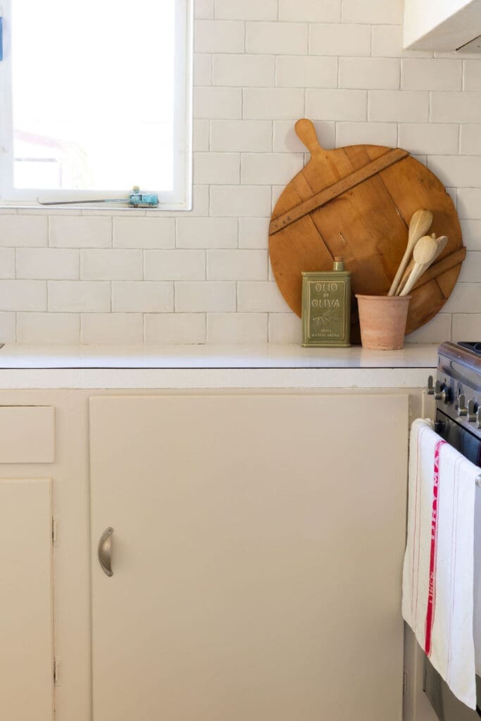 Kitchen bench styled with a timber bread board and ceramics in a staged Canberra ex-Govie cottage